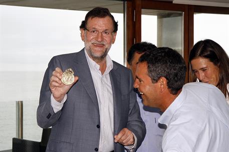 12/08/2014. El presidente Rajoy en el Real Club Naútico de Sanxenxo. El presidente del Gobierno, Mariano Rajoy, muestra la medalla conmemora...