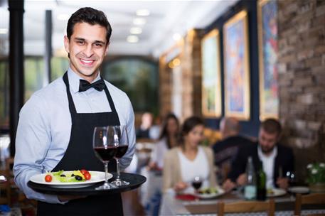 15/03/2024. A waiter serves tables in a restaurant. A waiter serves tables in a restaurant