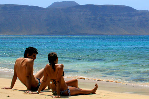 Turistas sentados a la orilla de la playa