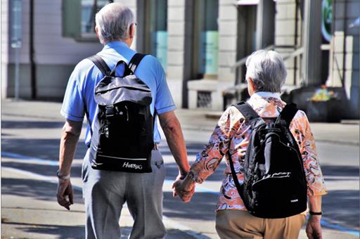 20/02/2019. Ancianos de espalda llevando mochilas
