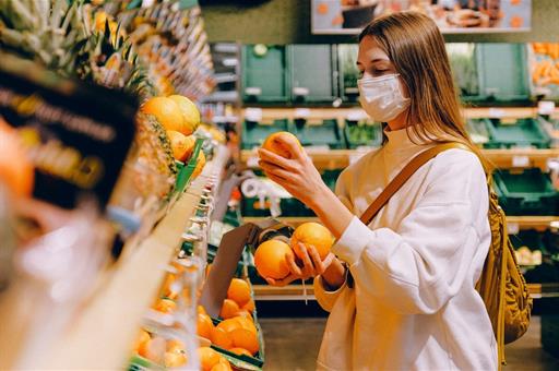 Clienta compra naranjas en una frutería