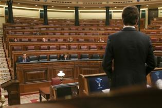 El presidente del Gobierno, Pedro Sánchez, sigue la intervención del líder del PP, Pablo Casado