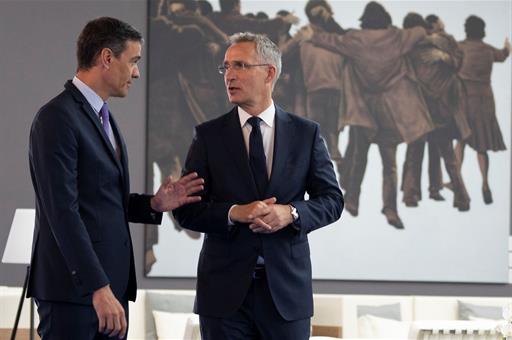 El presidente Pedro Sánchez y el secretario general de la OTAN ante el cuadro "El Abrazo"