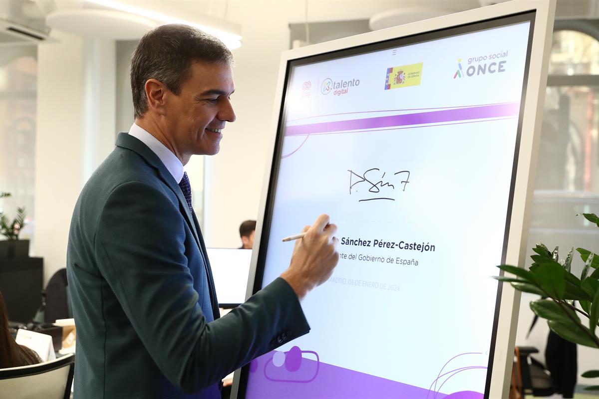 El presidente del Gobierno, Pedro Sánchez, firma en el libro de honor tras visitar el aula de formación tecnológica
