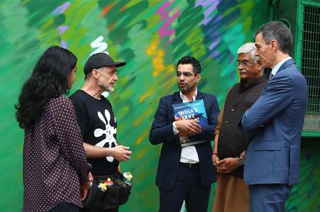 18/02/2026. Sánchez viaje india dia primer dia. El presidente del Gobierno, Pedro Sánchez, conversa con los artistas del mural hispano-indio...