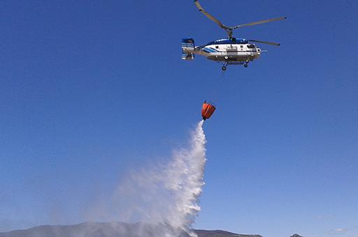 Helicóptero descargando agua para extinguir un incendio