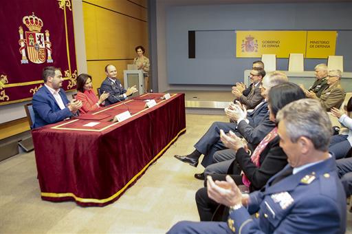 Margarita Robles, Javier Salto y Mario Ginés aplauden, junto al público, tras la firma del convenio