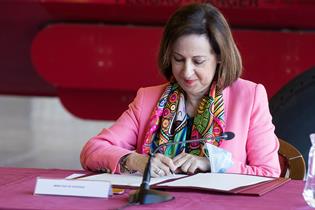 La ministra Robles firmando el acuerdo