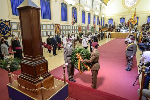 Dos militares sostienen una corona de laurel durante el acto de homenaje