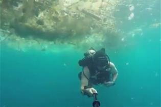 Submarinista buceando bajo una nube de plásticos