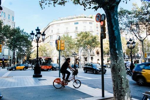 Calle con ciclistas, taxis, autobuses y turismos