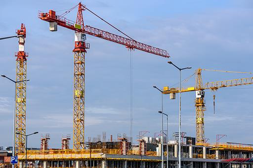 Grúas y bloque de viviendas en construcción