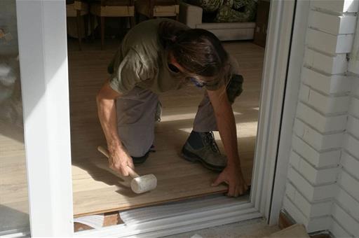 Trabajador colocando una tarima flotante en una vivienda