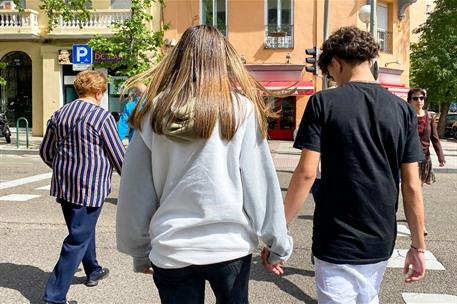 Pareja joven, de la mano, paseando