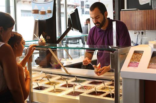 Un trabajador de la hostelería atiende a unos clientes