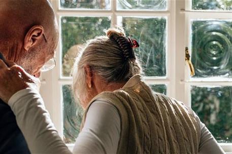 Un anciano ayuda a su mujer