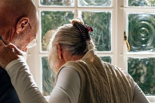 Un anciano ayuda a su mujer