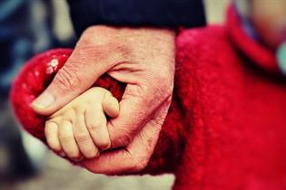 Un adulto sujetando la mano de un niño