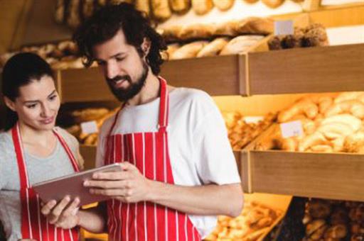 Dos trabajadores en su establecimiento comercial