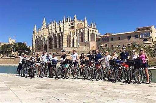 Turistas visitando Palma de Mallorca en bicicleta