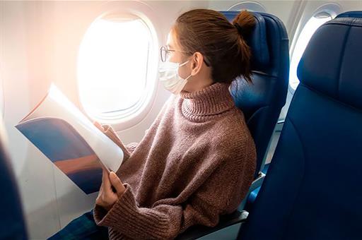 Pasajera con mascarilla en un avión