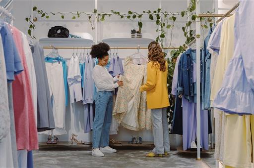 Dos clientas compran ropa en un pequeño comercio