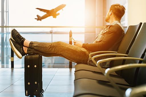 Un viajero viendo despegar un avión en un aeropuerto