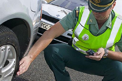 Agente de la Guardia Civil mirando la presión de los neumáticos Agente de la Guardia Civil mirando la presión de los neumáticos