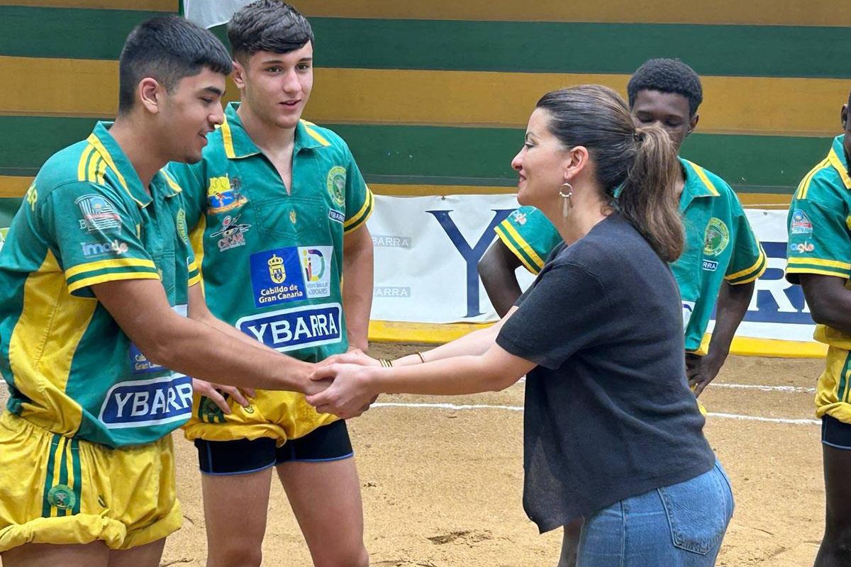 La ministra de Juventud e Infancia, Sira Rego, saluda a uno de los miembros del Club de Lucha Unión Gáldar Ybarra