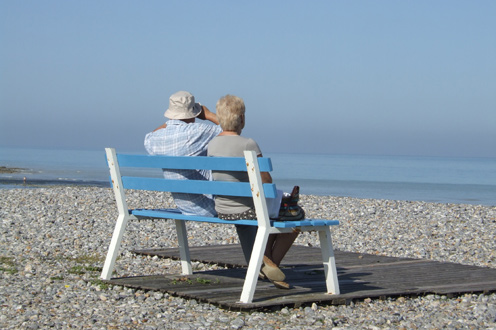 Pareja de ancianos en un banco frente al mar