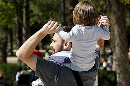 Hombre con un niño a hombros Hombre con un niño a hombros