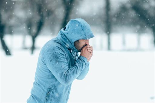 Un hombre camina bajo la nieve