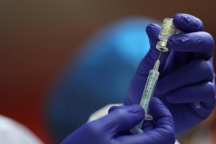 Un sanitario extrae una dosis de vacuna con una jeringuilla