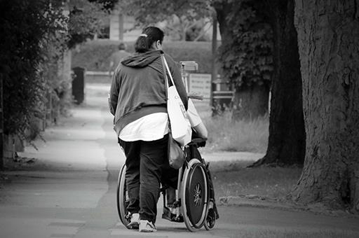 Cuidadora con persona mayor en silla de ruedas 