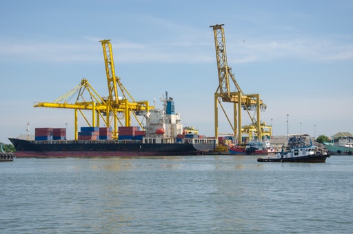 Un puerto con barcos que llevan contenedores